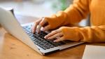 An asian woman's hand typing on a computer